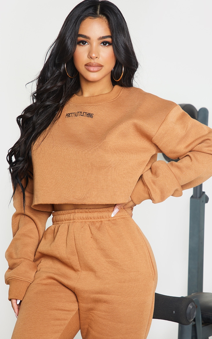 PRETTYLITTLETHING Petite - Sweat court camel à slogan brodé
