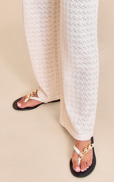 Sandale blanche à entre-doigt et détails métalliques dorés