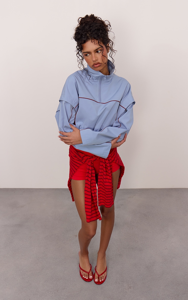 Veste coupe-vent bleu clair à zip et lisérés contrastants