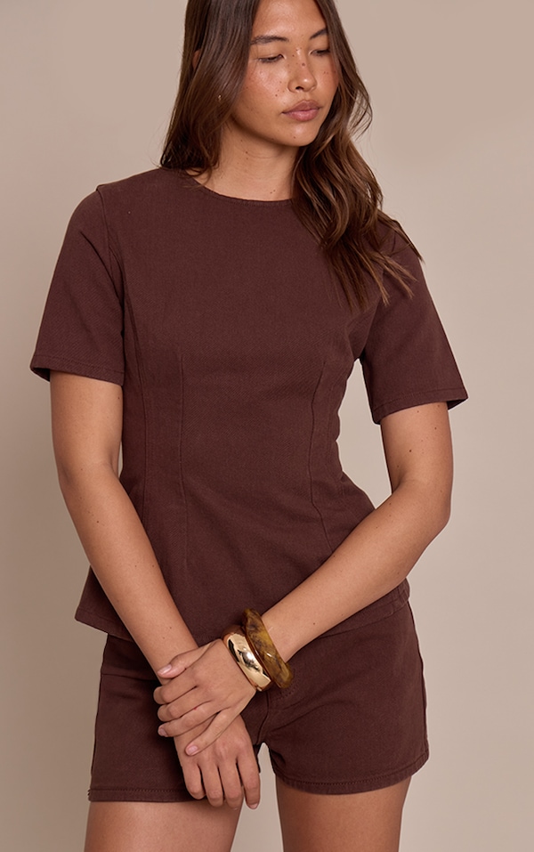Top en denim chocolat à basque et taille cintrée.