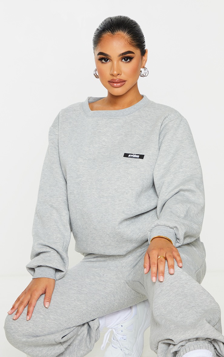 PRETTYLITTLETHING Petite - Sweat oversize gris à slogan Studio