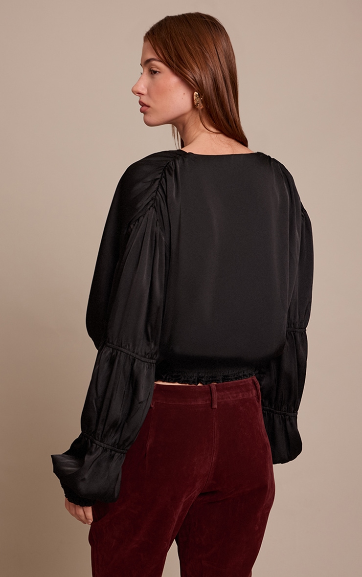 Blouse satinée noire à décolleté et volants image 2