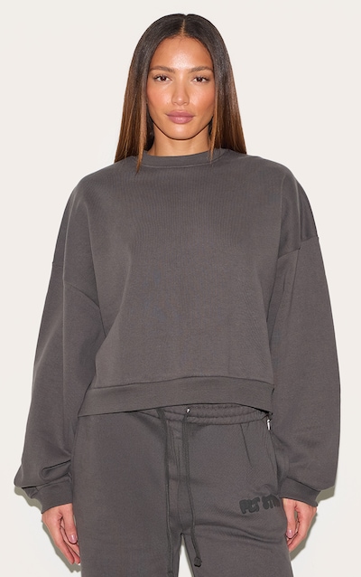 PRETTYLITTLETHING Tall Sweat deluxe gris anthracite à épaules carrées et imprimé "PLT Studio