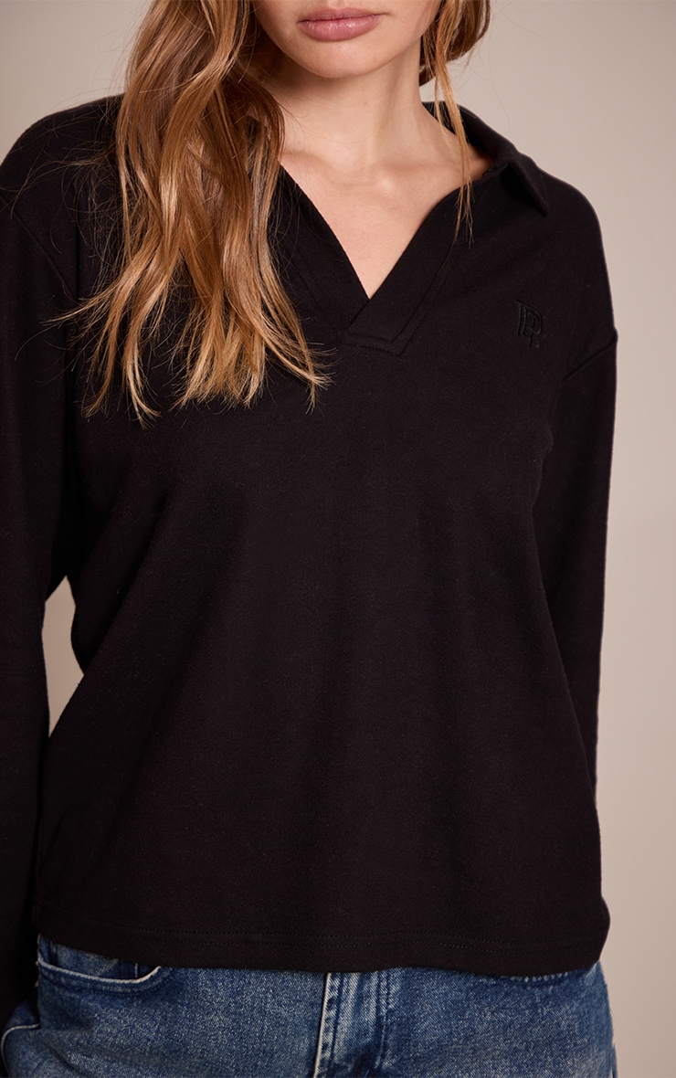 Top long noir à col replié et logo brodé image 4