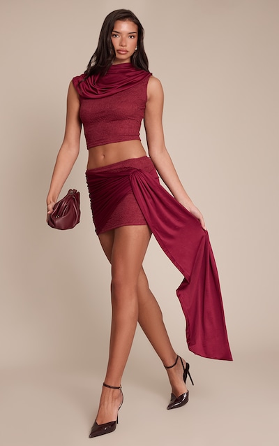 Mini-jupe moulante en dentelle rouge vin foncé à partie drapée