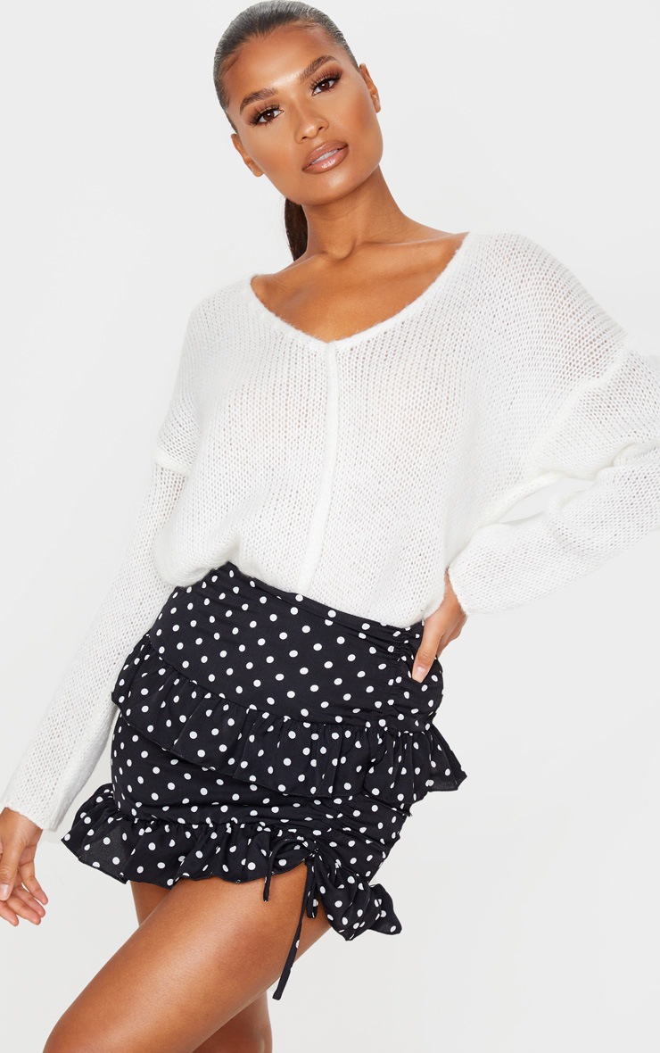 Mini-jupe noire en maille tissée à volants et imprimé pois