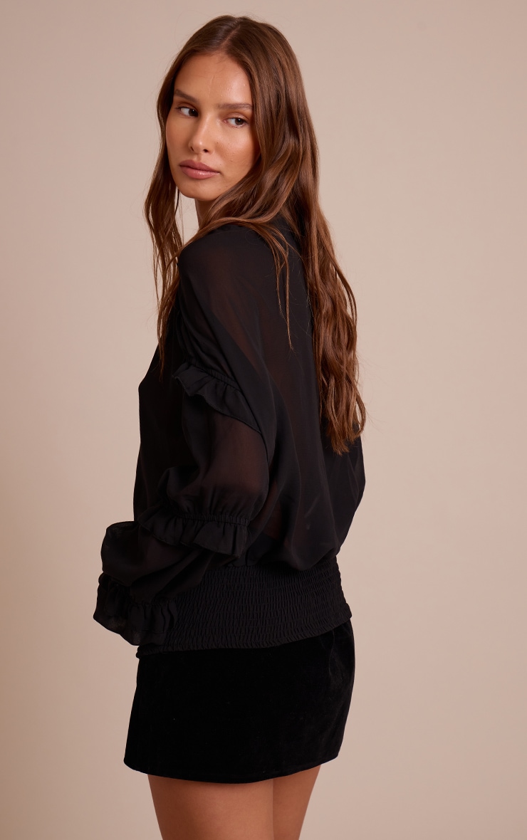 Blouse noire en mousseline de soie, à décolleté plongeant et détails à volants. image 2